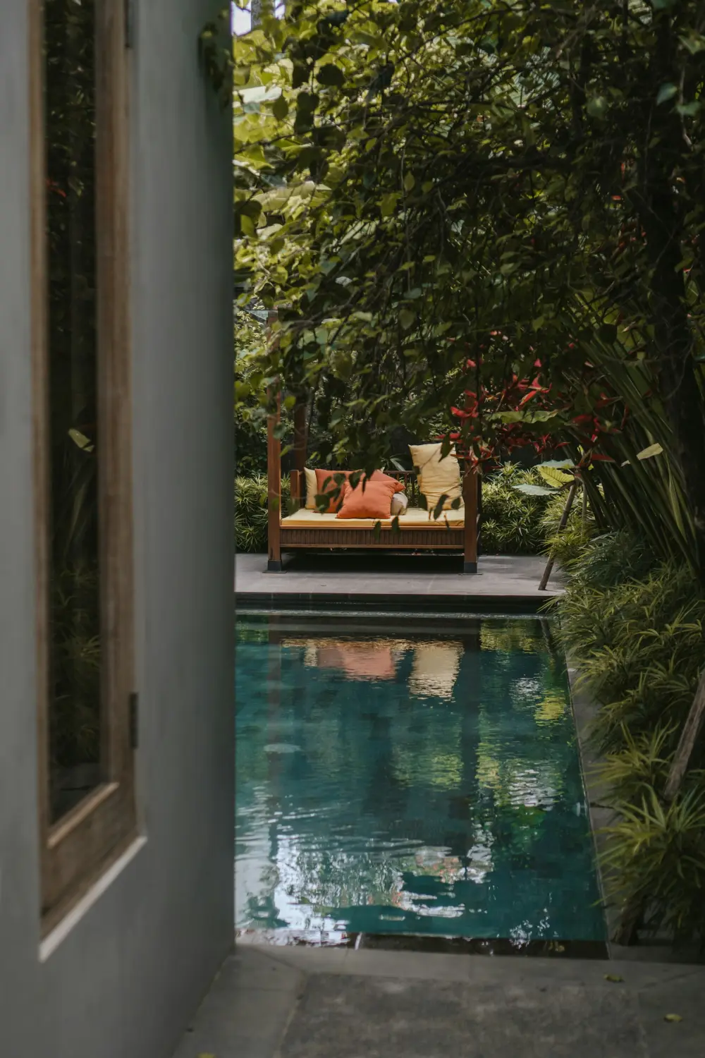 Secluded poolside daybed surrounded by greenery